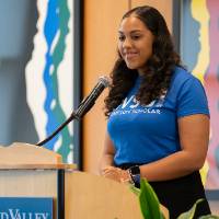 A student who received a Thompson scholarship is speaking at the podium.